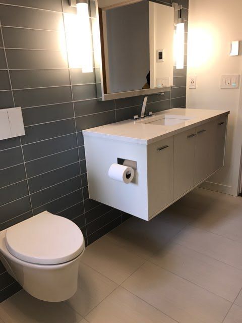 A bathroom with a toilet a sink and a mirror.