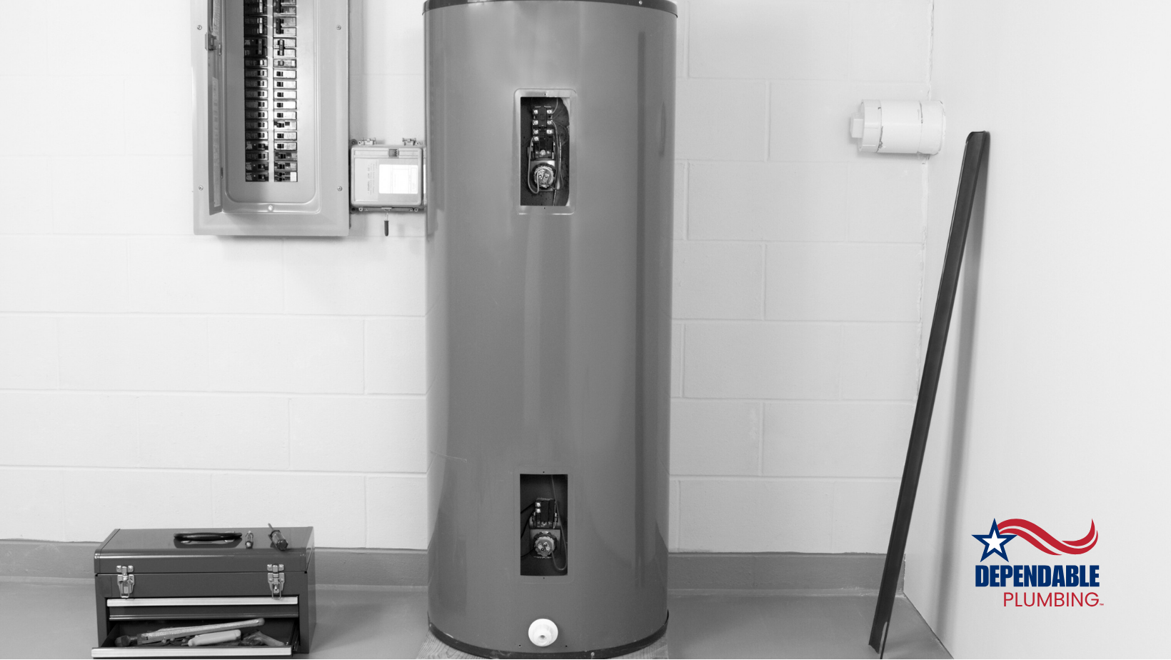 A gray water heater is sitting in a room next to a wall.