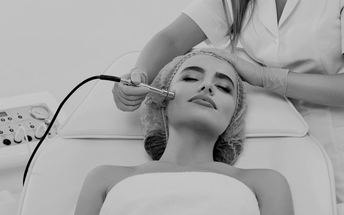 Una persona riceve un trattamento viso di microdermoabrasione mentre è sdraiata su un lettino da spa.