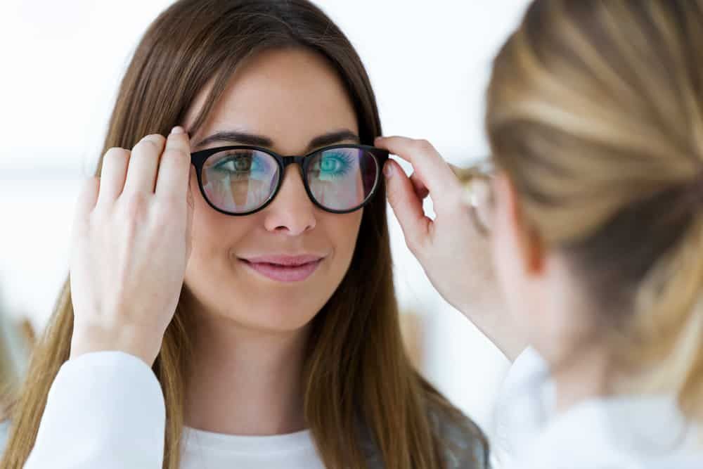 A Woman is Trying on Glasses in Front of a Mirror — Eyepower In Bargo, NSW