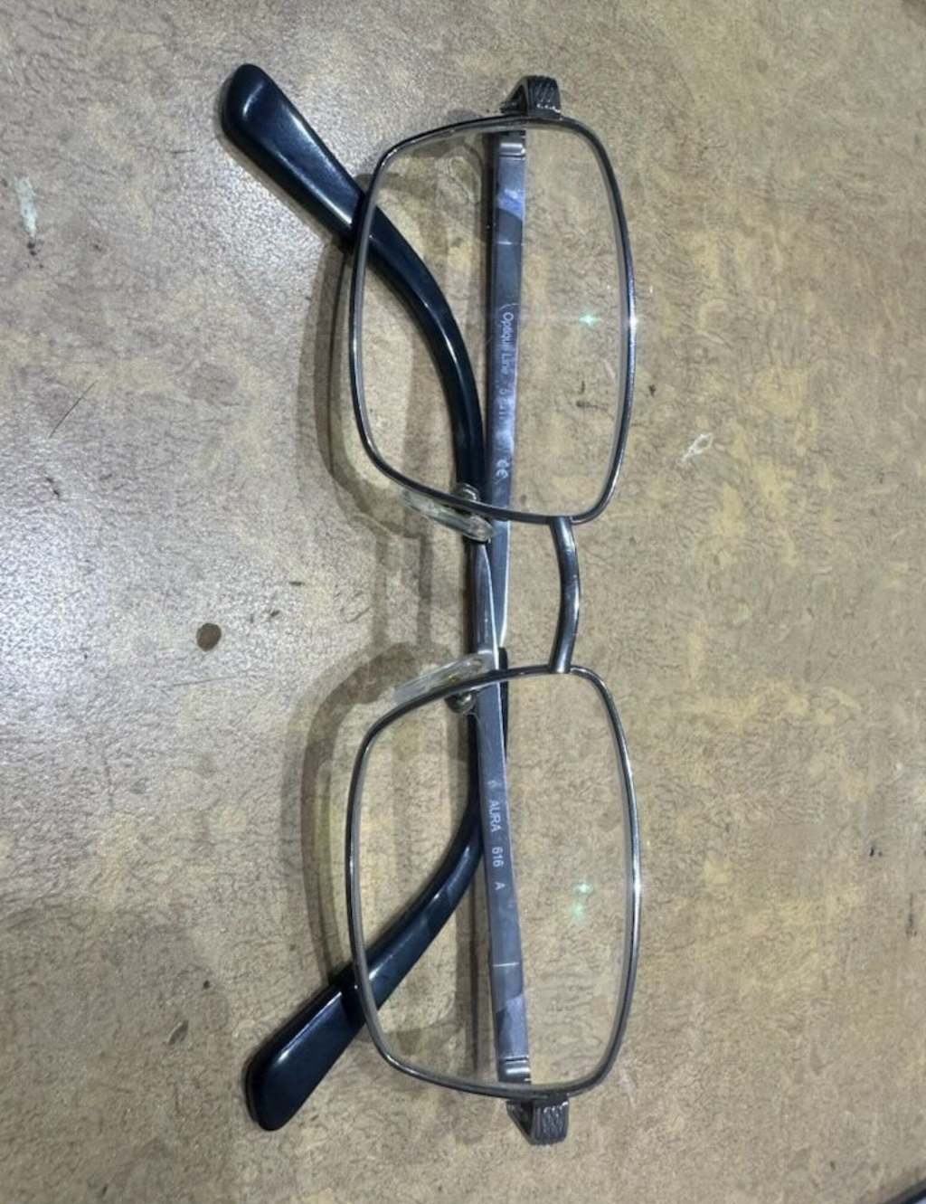 Black-Rimmed Eyeglasses with Clear Lenses Resting on A Wooden Surface — Eyepower In Tahmoor, NSW