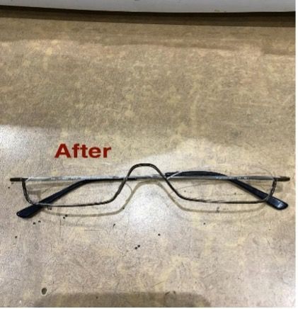 Black wire-rimmed glasses with semi-rimless lenses, on a textured tan surface, labelled 