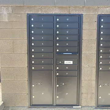 A row of mailboxes on a brick wall.