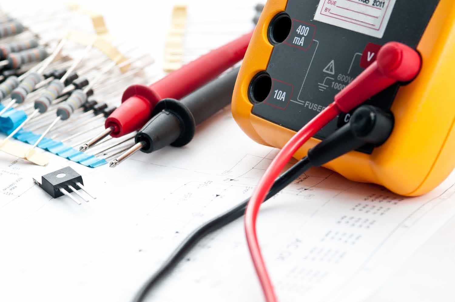 A yellow multimeter is sitting on top of a piece of paper.