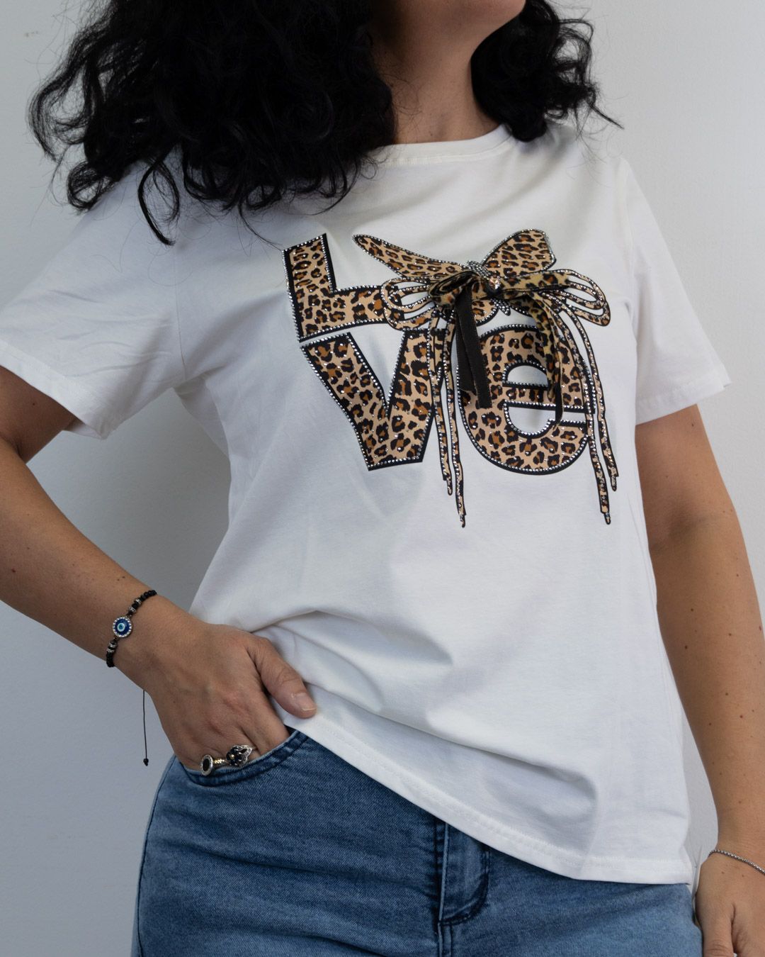 Mujer que lleva una camiseta blanca con la palabra "LOVE" en estampado de leopardo.