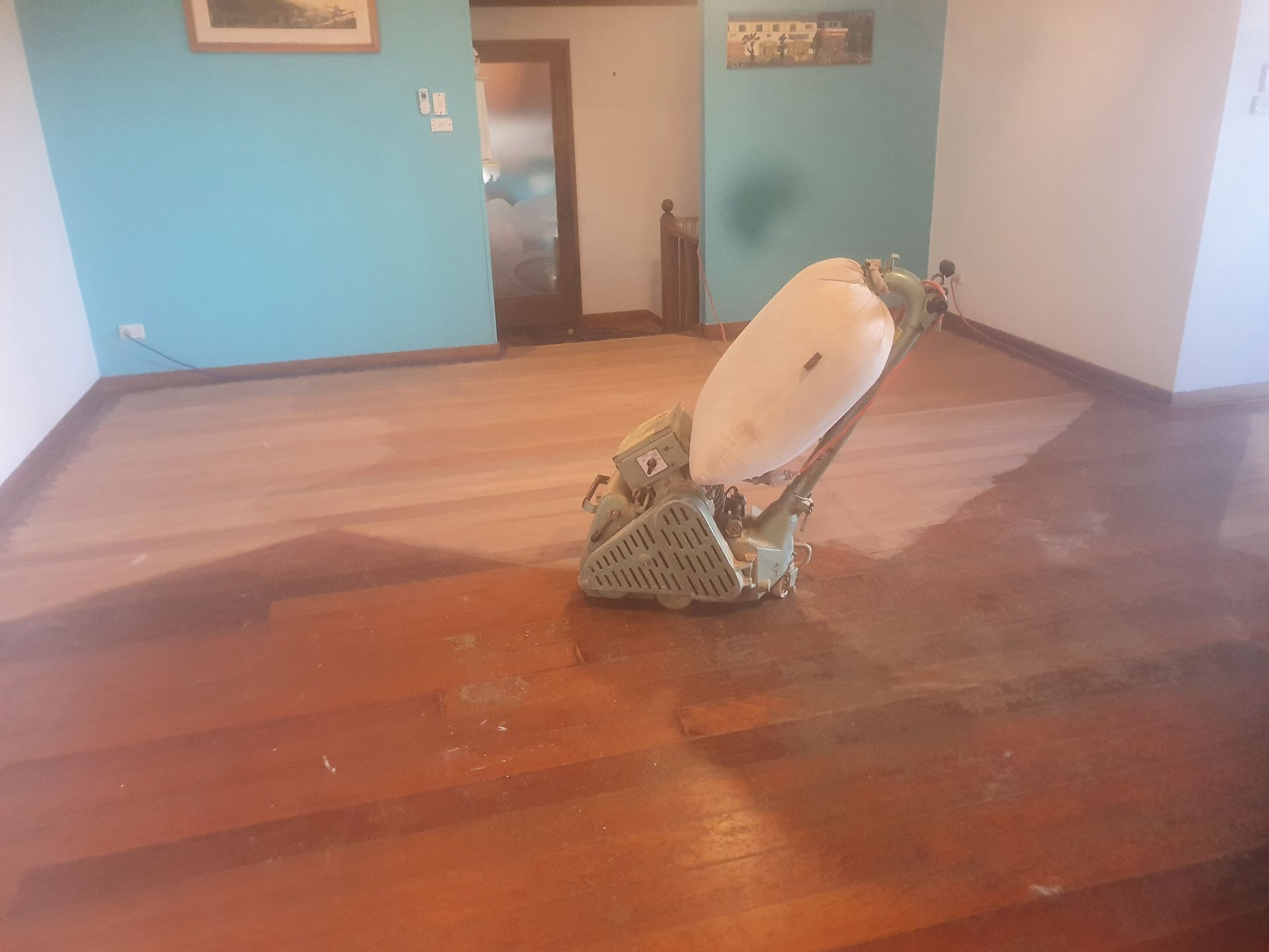 A machine is sitting on a wooden floor in a room. A machine is sitting on a wooden floor in a room.