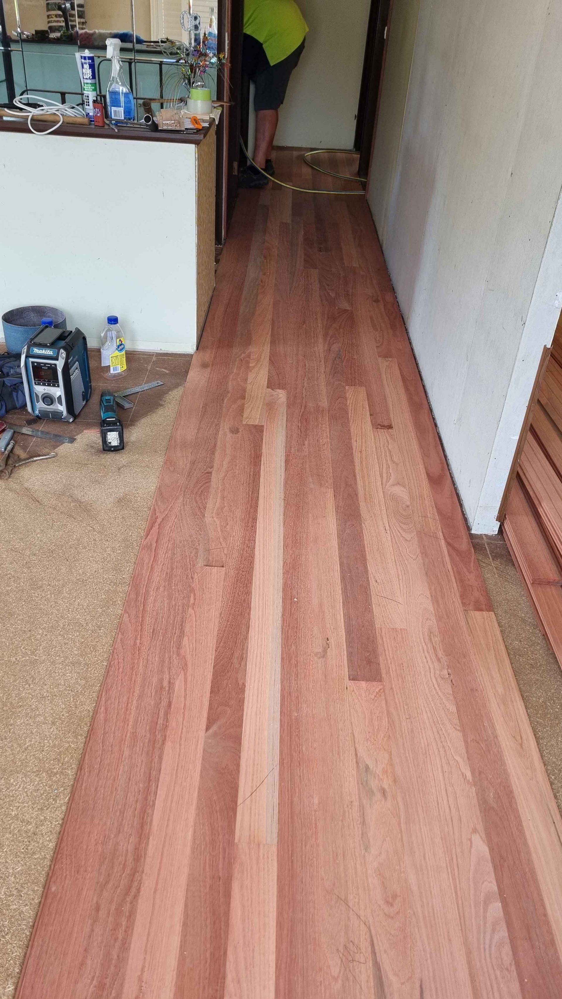 A person is standing on a wooden floor in a room.