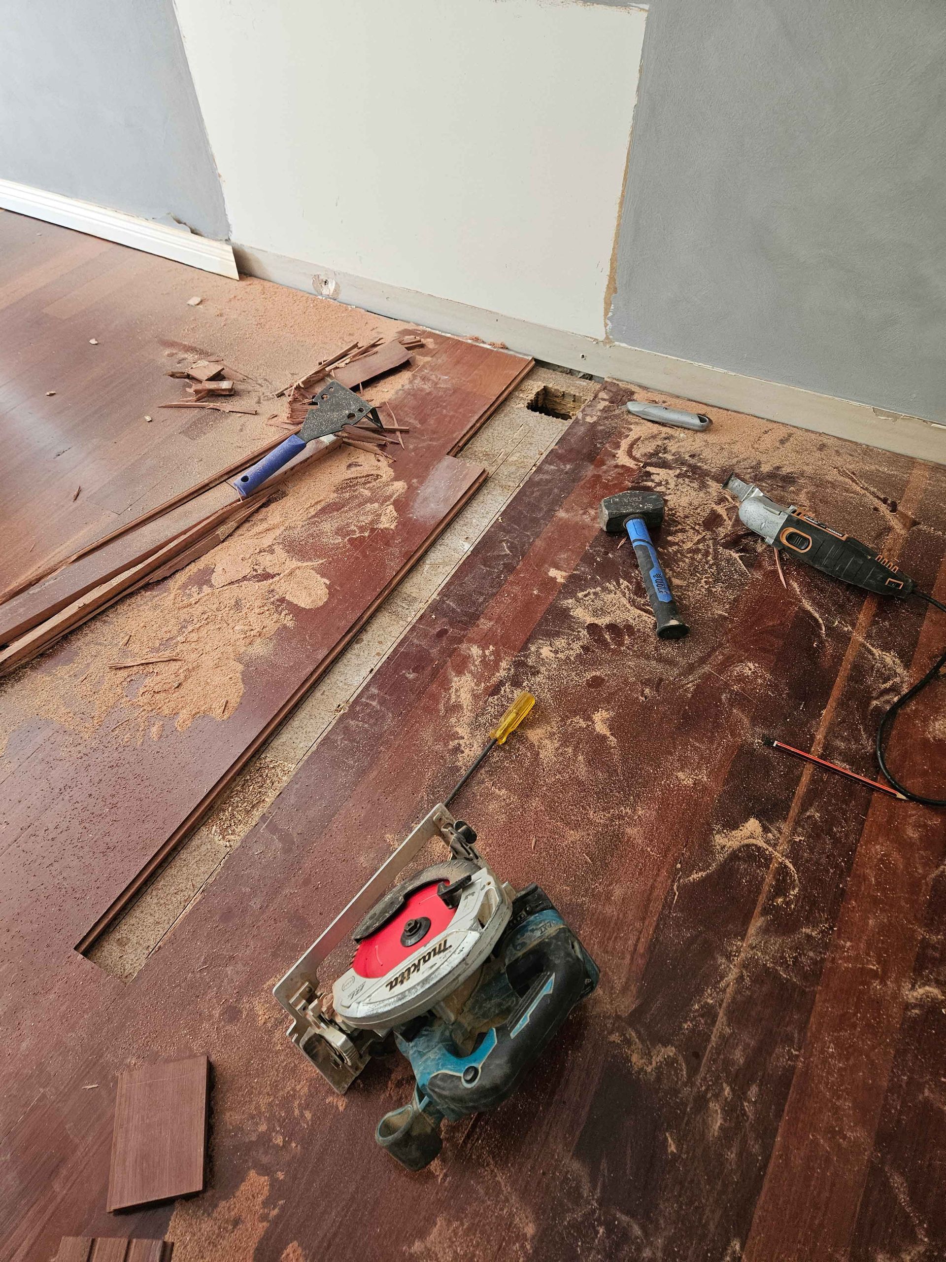 A wooden floor with a lot of tools on it.
