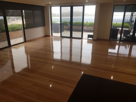 A living room with a wooden floor and lots of windows.