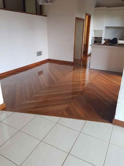 A living room with a wooden floor and white tiles.