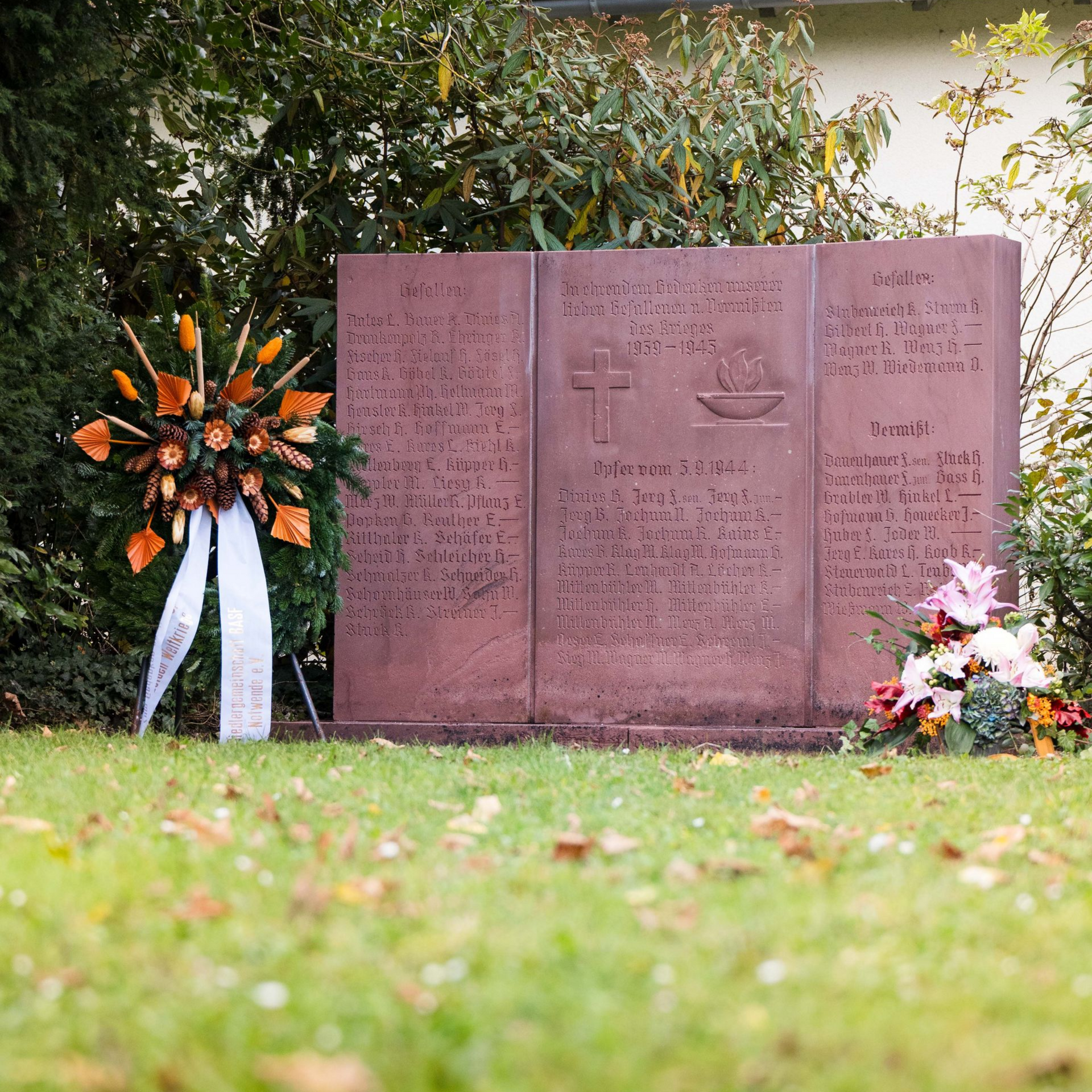 Ehrenmal in der Altrheinstraße in Ludwigshafen Oggersheim, davor sind Kränze zum Andenken an die Kriegsopfer des ersten und zweiten Weltkrieges niedergelegt. 