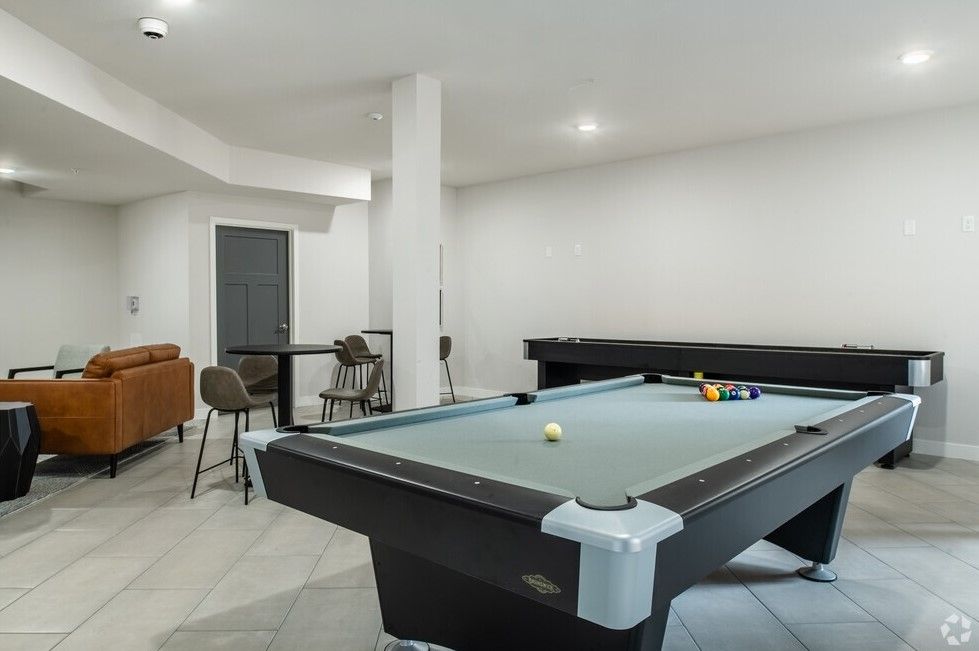 There is a pool table in the middle of the room.