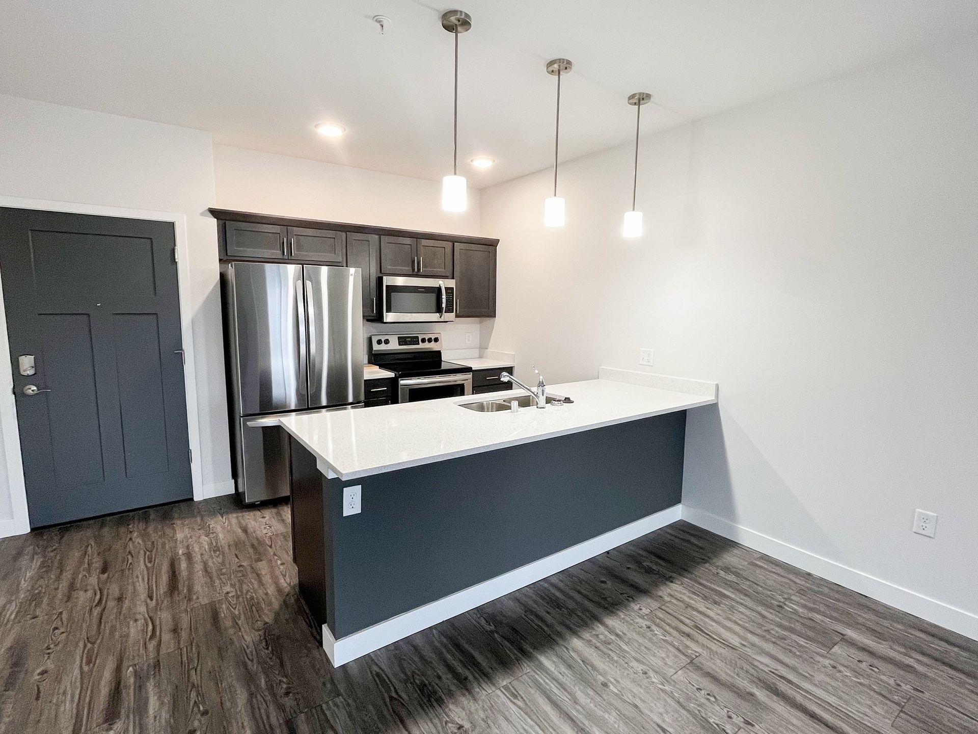 A kitchen with stainless steel appliances and a large island.