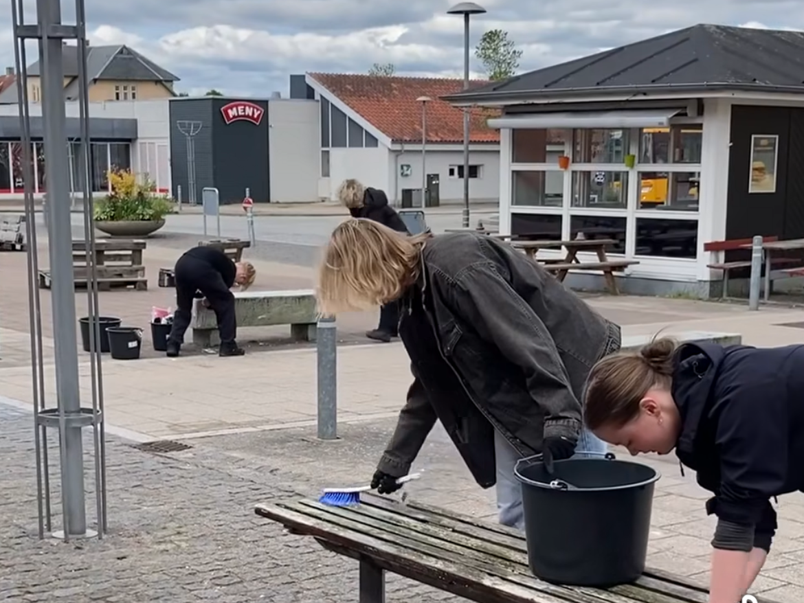 En gruppe mennesker gør bænke rent 