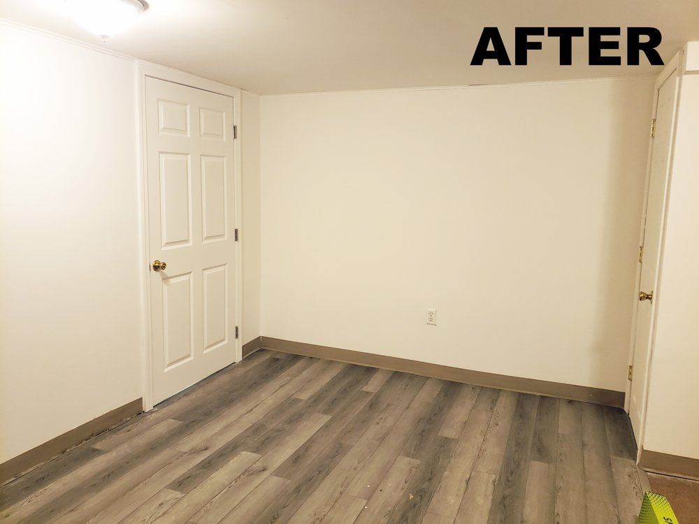 Empty room with white walls, white door, and gray wood-look flooring, labeled “AFTER”