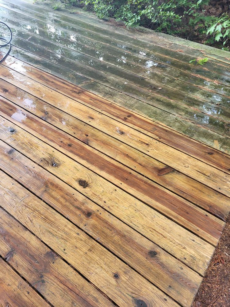 Rain-soaked wooden deck with wet planks and a garden edge in the background