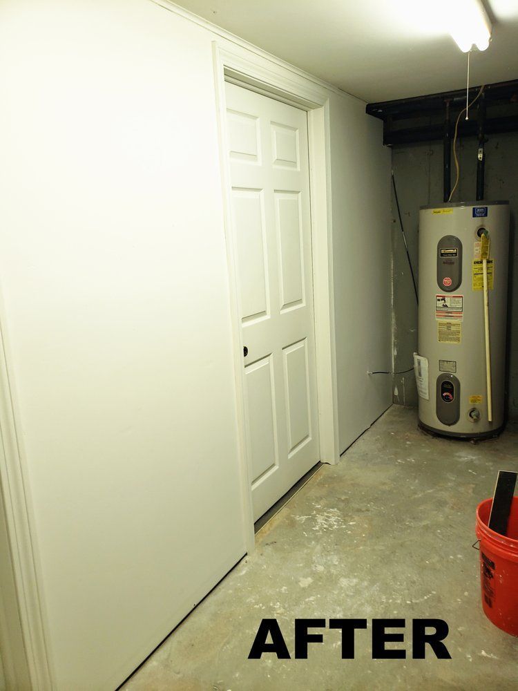 Finished basement with white closet doors and a water heater on the right, labeled “AFTER”