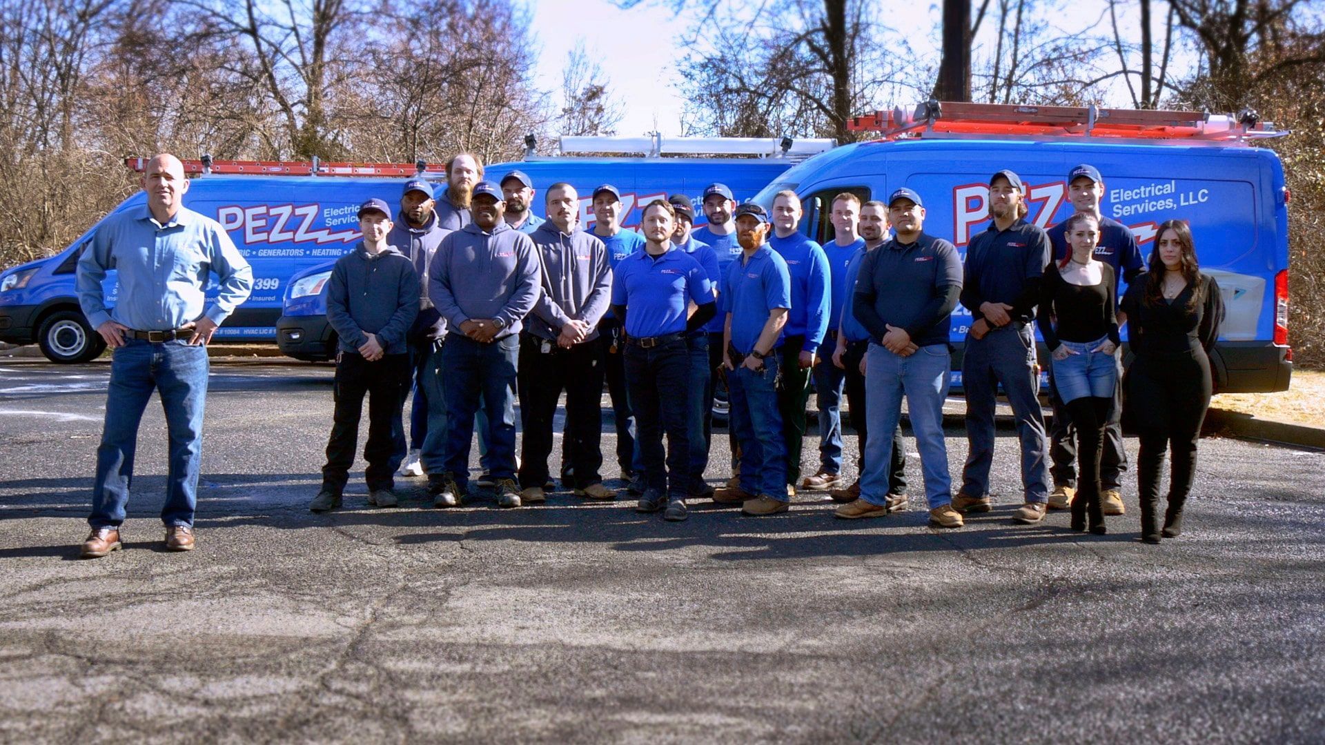 A group of people are posing for a picture in front of a van.