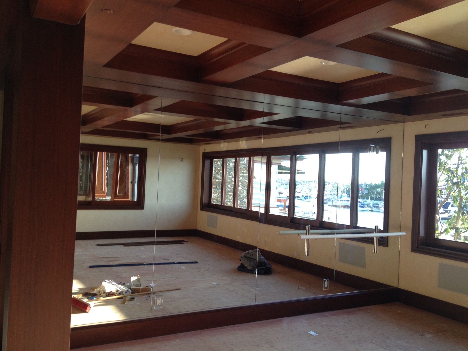 Interior room with dark wooden beams on ceiling, windows, and light-colored walls.