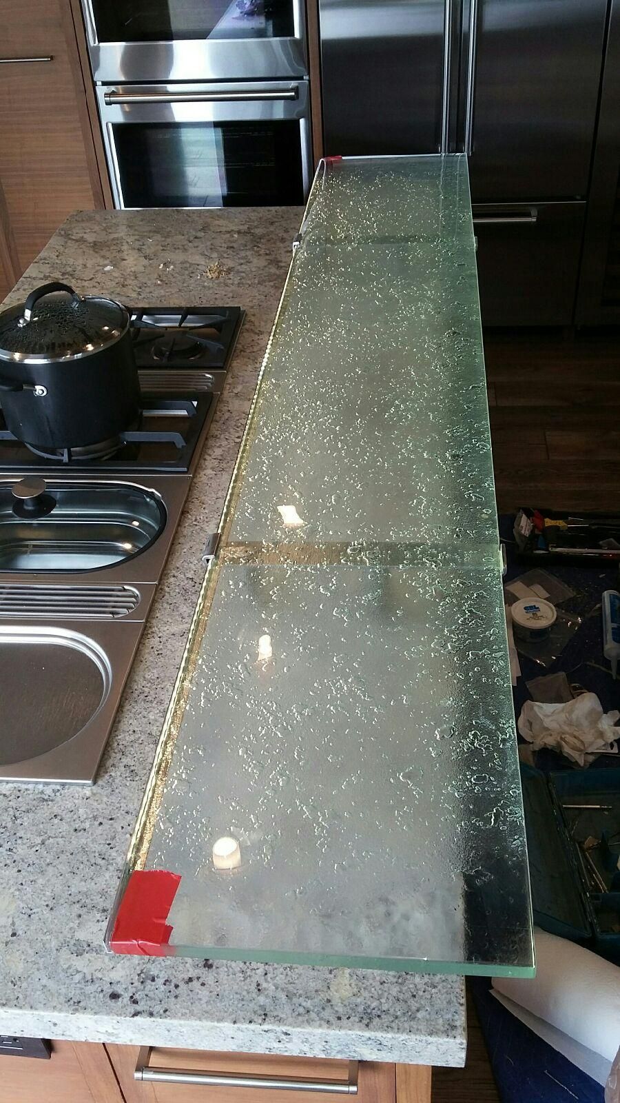 Glass countertop extension with embedded glitter, on a kitchen countertop, near a stove.