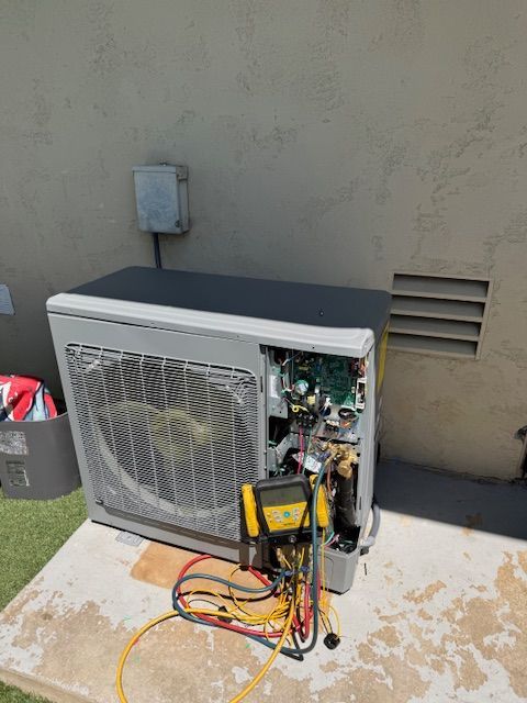 A broken air conditioner is sitting on top of a wooden table.