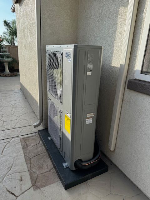 A large air conditioner is sitting on the side of a building.