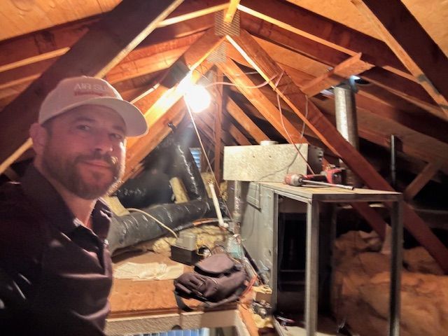 A man in an attic with a hat that says ' abercrombie & fitch ' on it