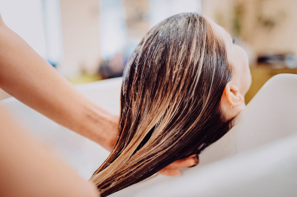 A Woman is Washing Her Hair in a Sink at a Salon — Hair It Is In Balgownie, NSW