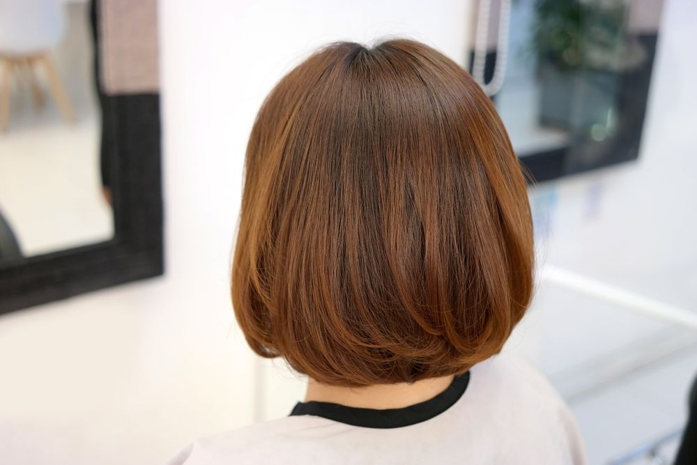 A Woman With Short Brown Hair is Sitting in Front of a Mirror — Hair It Is In Mount Ousley, NSW