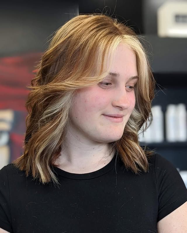 A Young Woman with Blonde Hair Is Wearing a Black Shirt and Smiling — Hair It Is In Balgownie, NSW