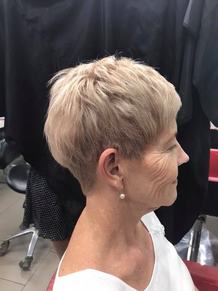 A Woman with Short Blonde Hair Is Sitting in A Chair — Hair It Is In Balgownie, NSW