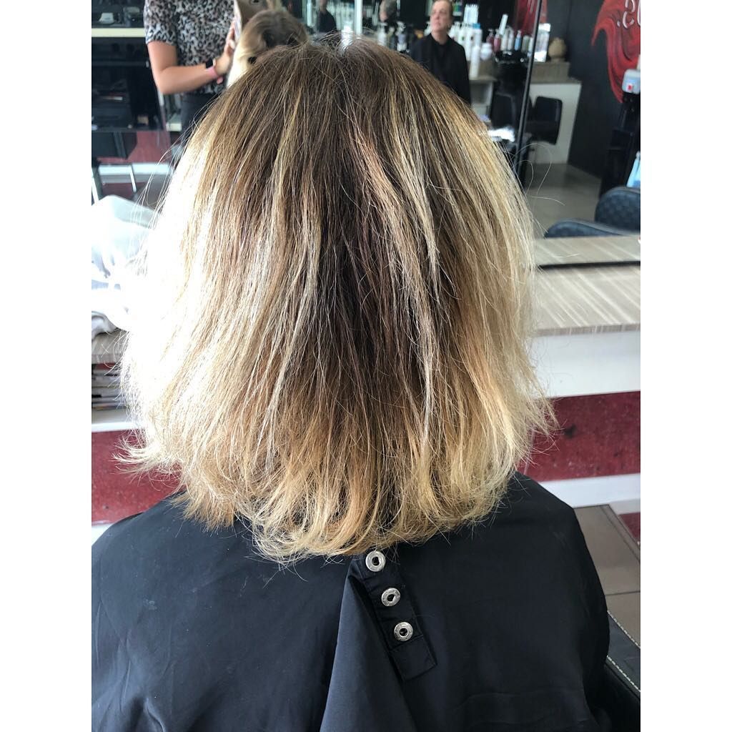 A Woman Is Getting Her Hair Cut in A Salon — Hair It Is In Balgownie, NSW