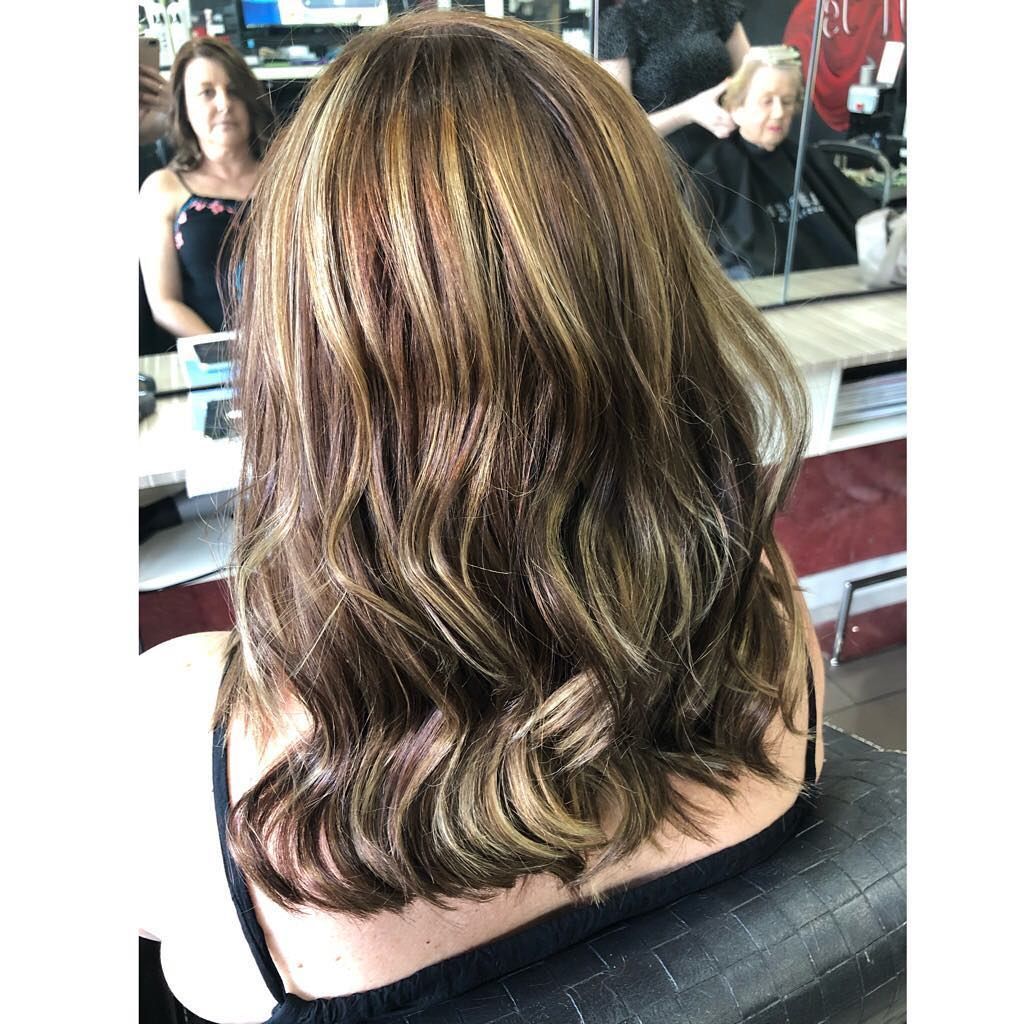 A Woman with Long Brown Hair Is Sitting in A Chair in Front of A Mirror — Hair It Is In Balgownie, NSW