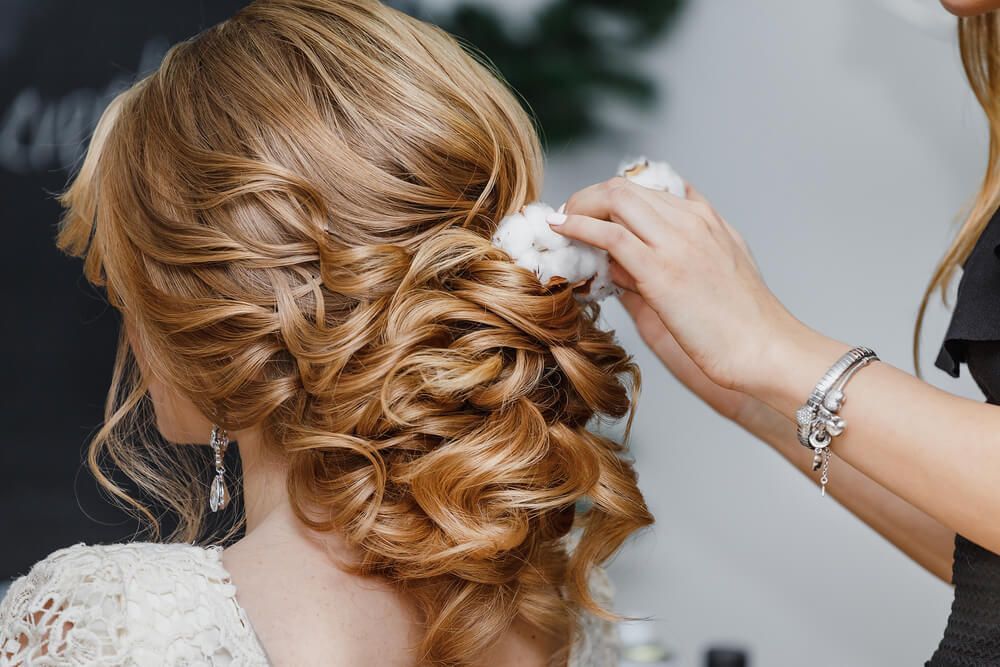 Hair stylist creating a wedding hairstyle for a bride — Hair It Is In Balgownie, NSW