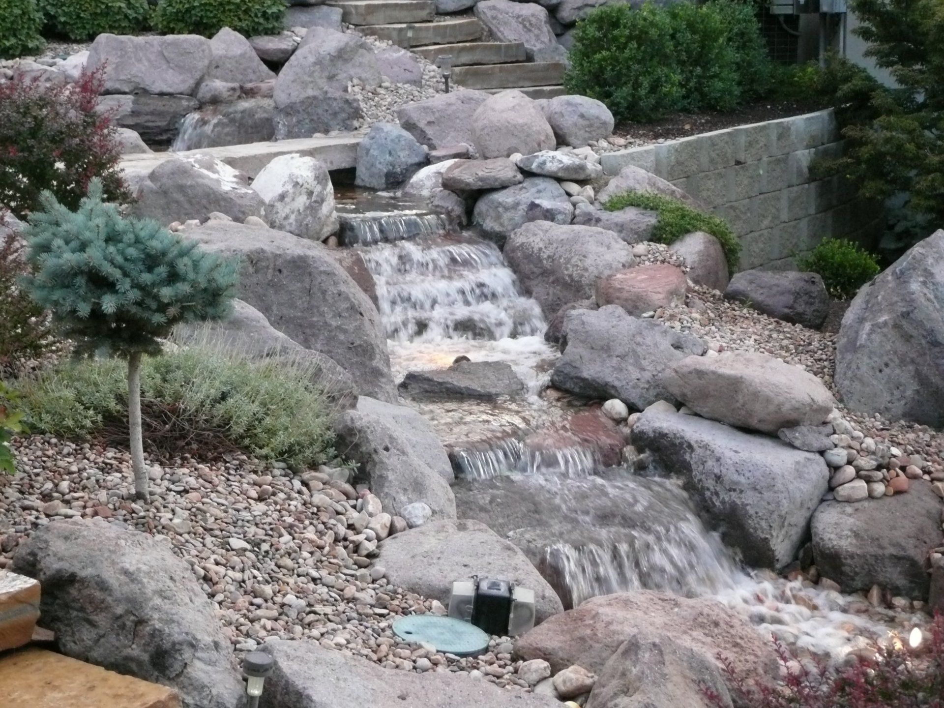 A man is working on a stone wall with a tractor in the background