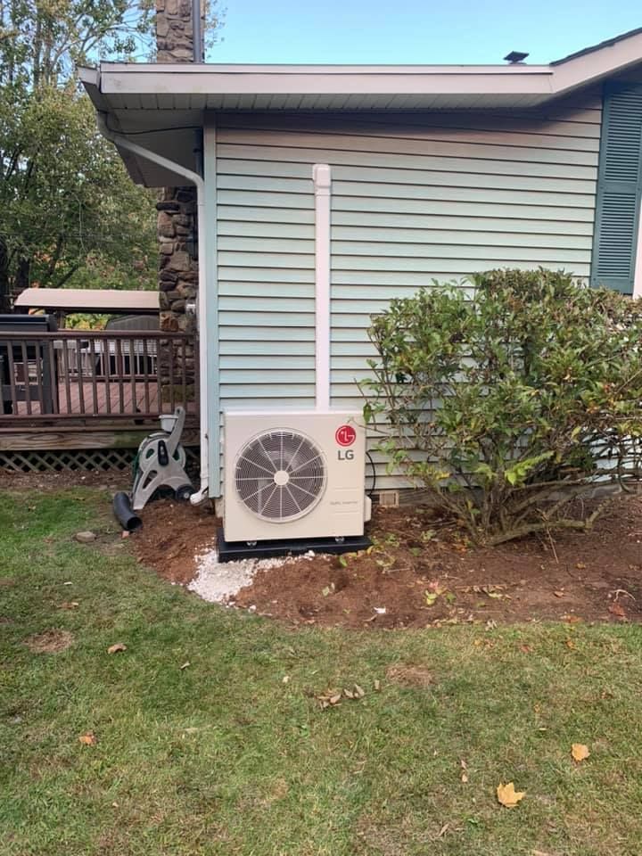 An lg air conditioner is installed on the side of a house.