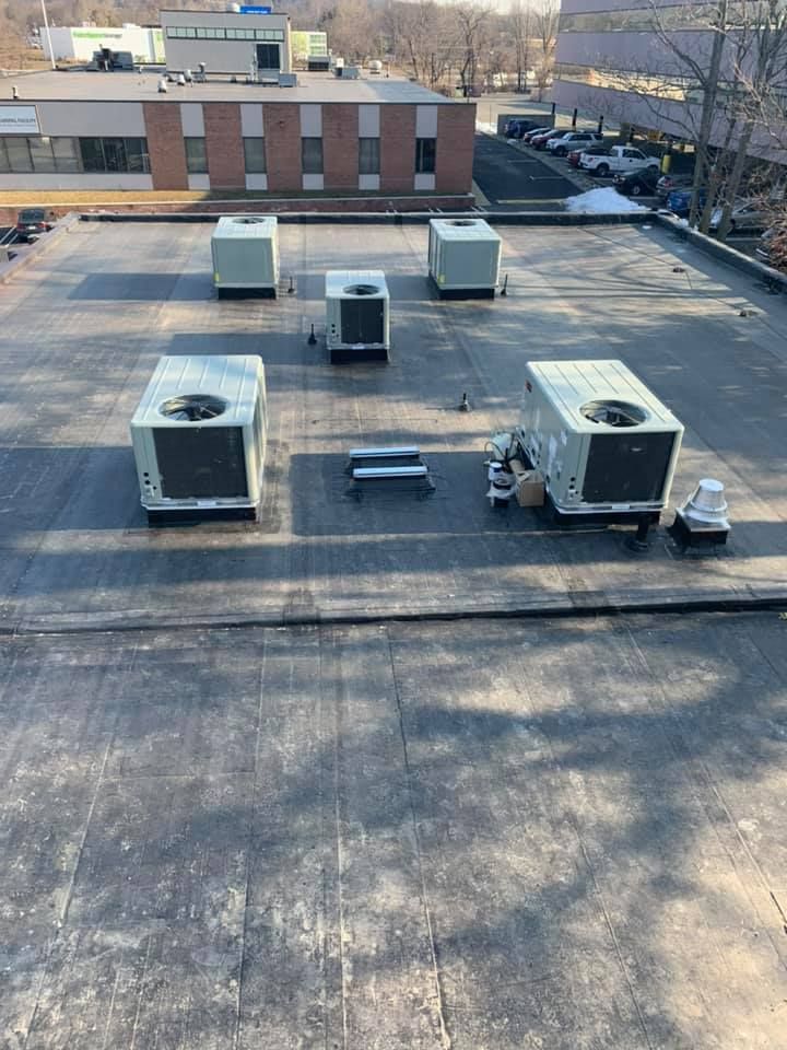 The roof of a building with a lot of air conditioners on it.
