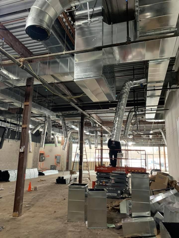 A man is standing on a ladder in a building under construction.