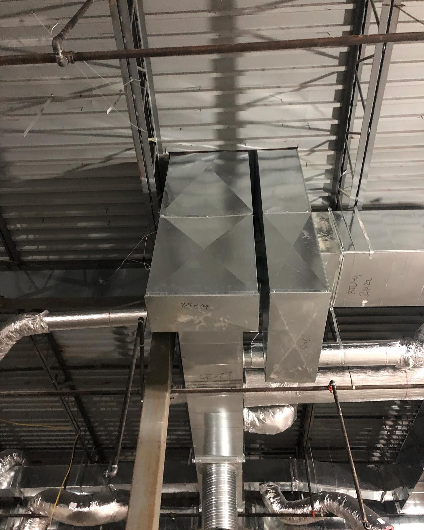 A metal pipe is hanging from the ceiling of a building.