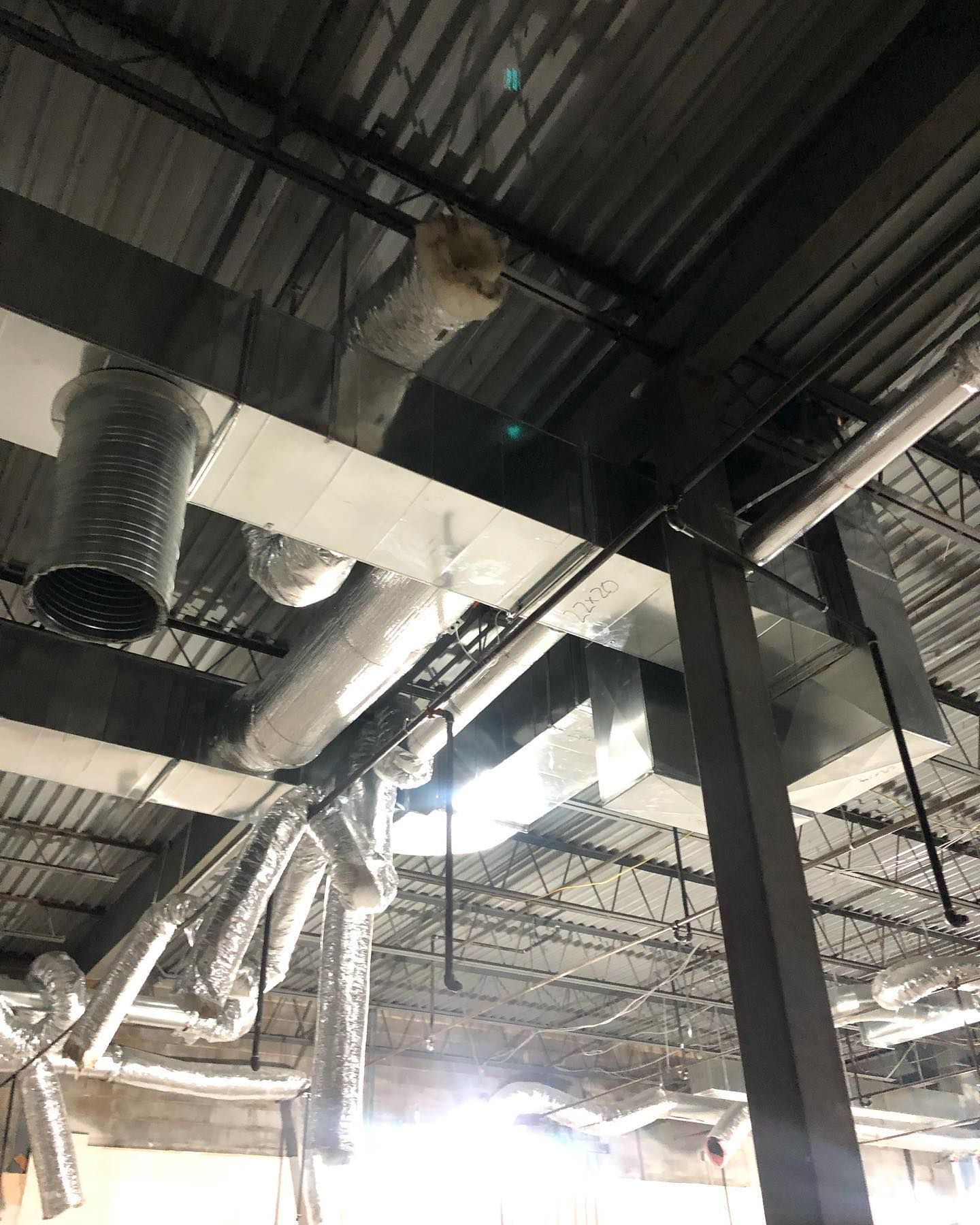 There are a lot of pipes hanging from the ceiling of a building.