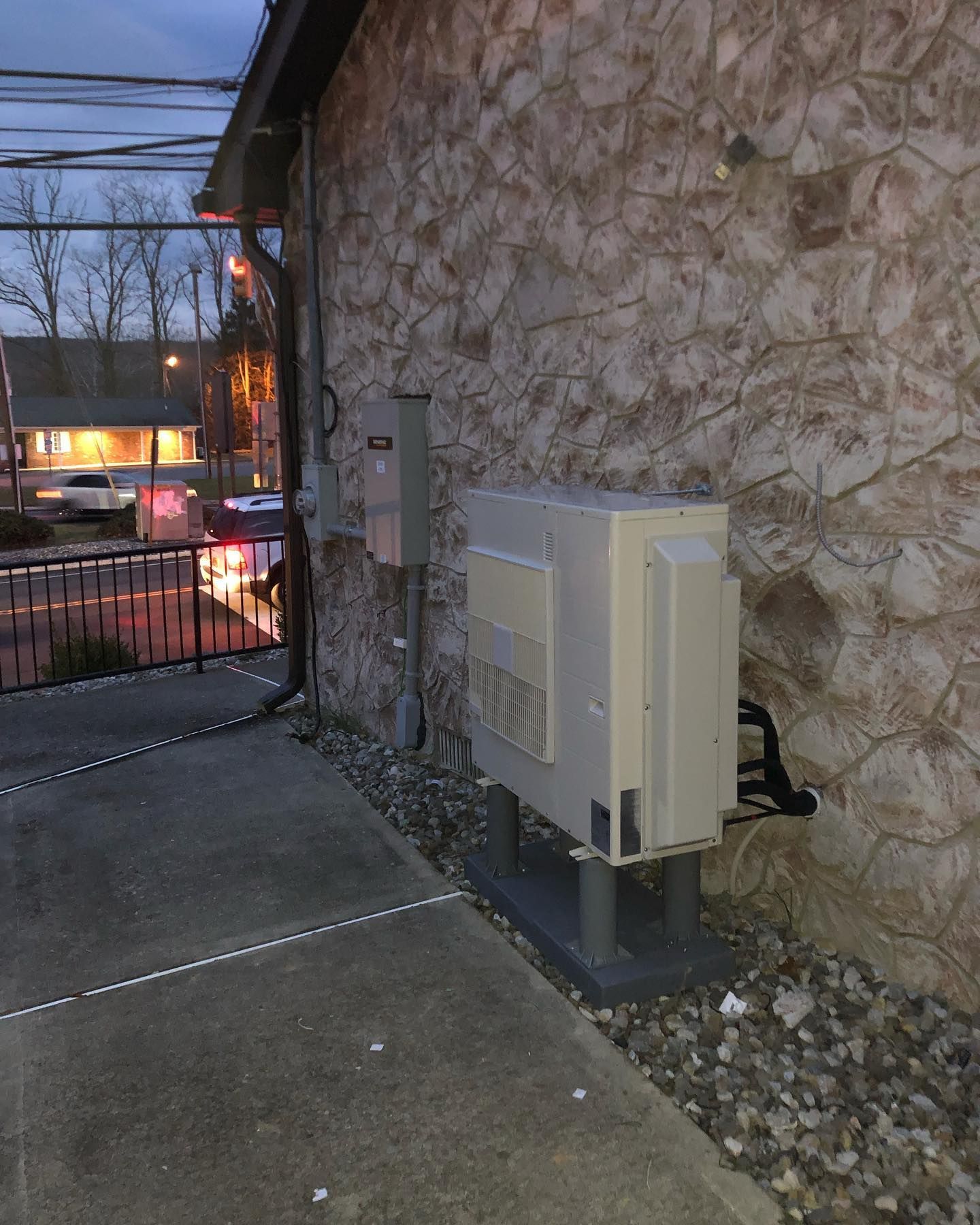 A white box is sitting on the side of a building.