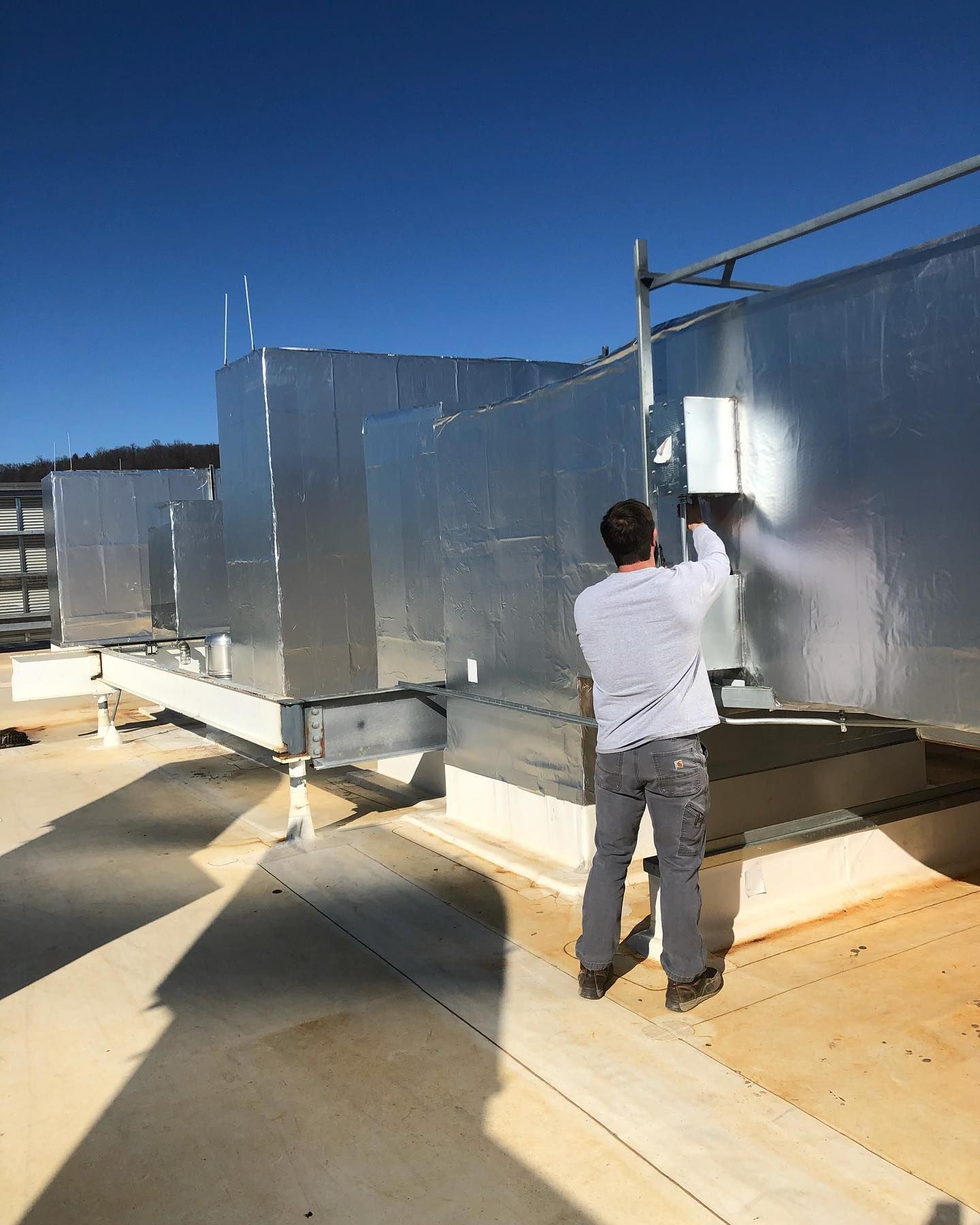 A man is standing on the roof of a building.
