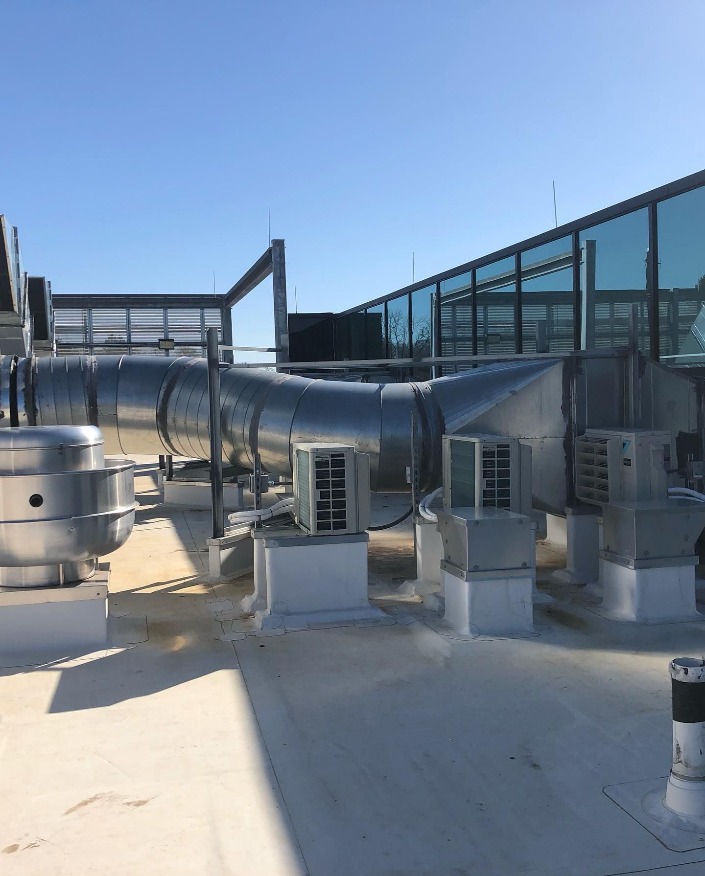 There are a lot of pipes on the roof of a building.