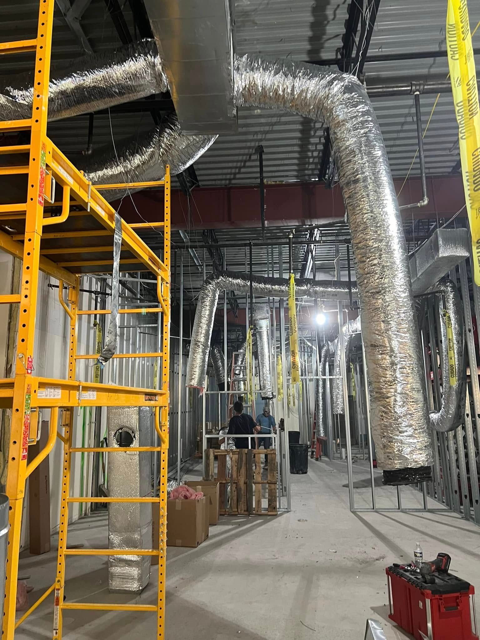 A large room with a lot of pipes and scaffolding.