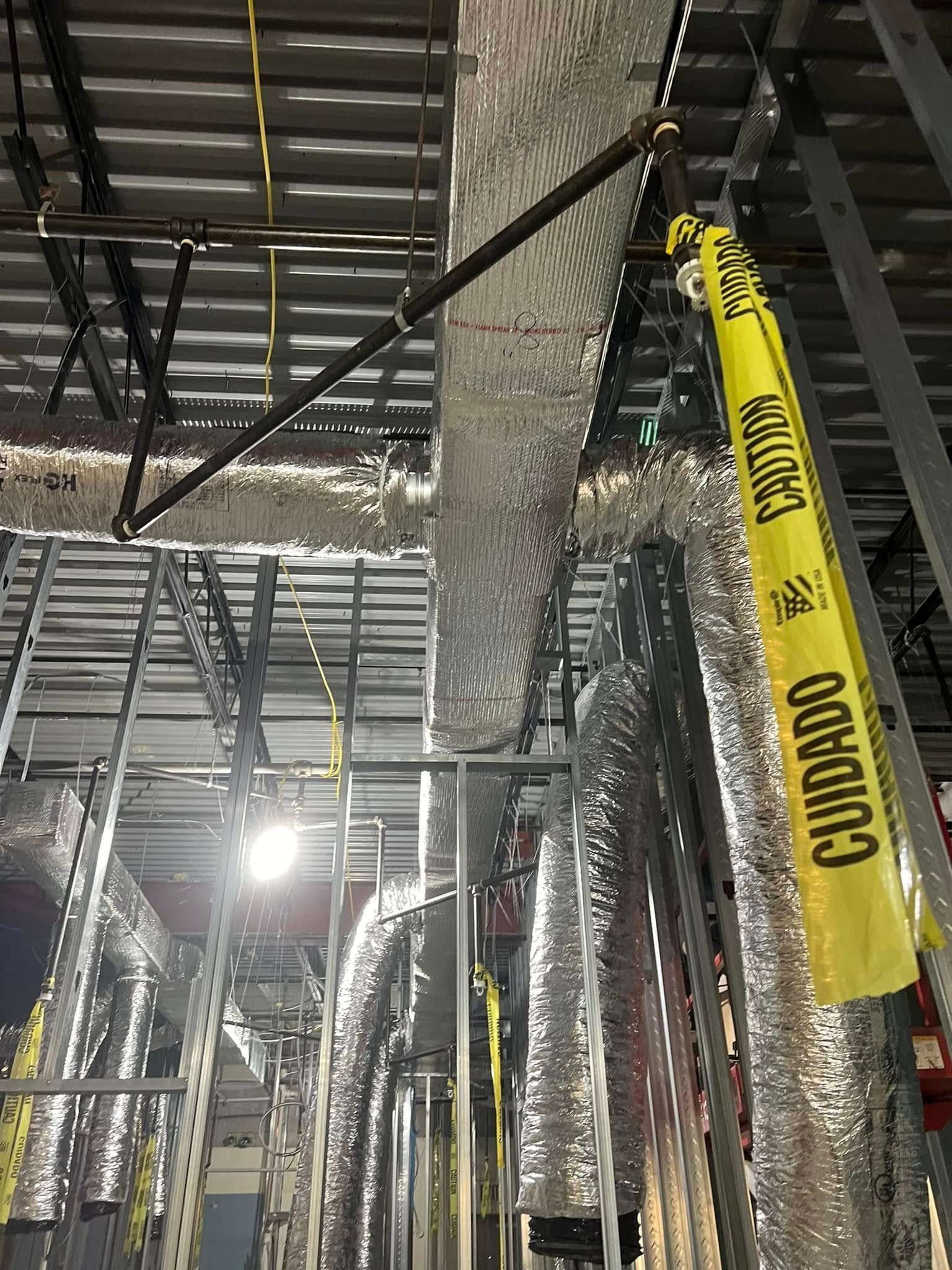 There is a yellow caution tape hanging from the ceiling of a building.