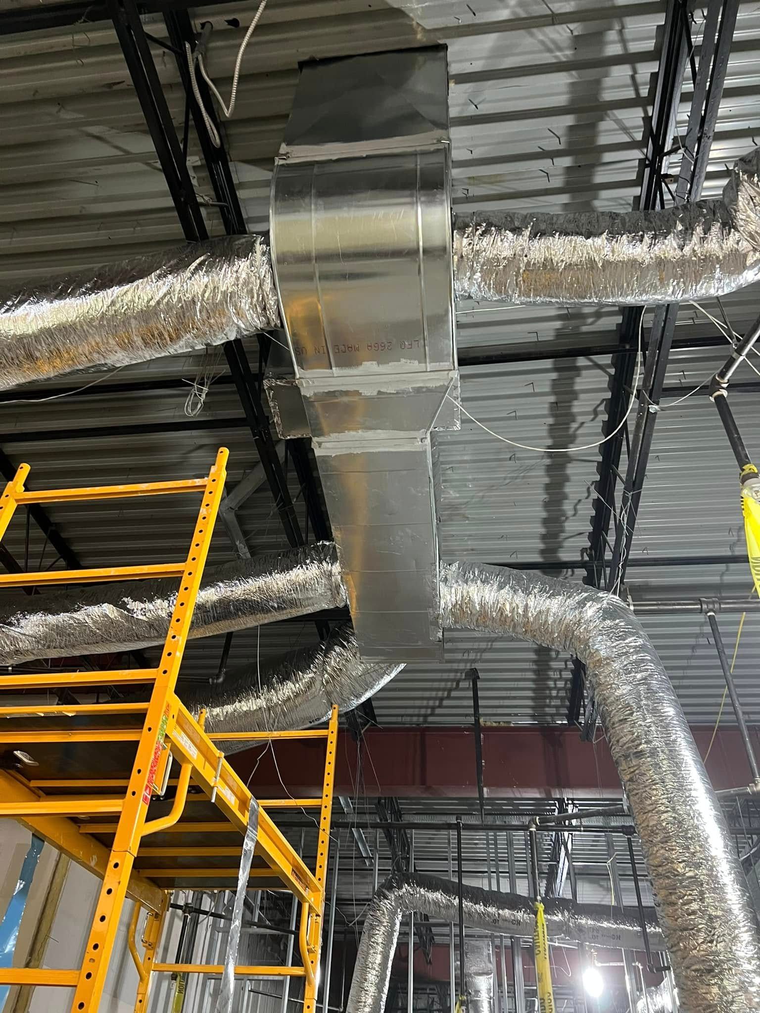 A large metal pipe is hanging from the ceiling of a building.