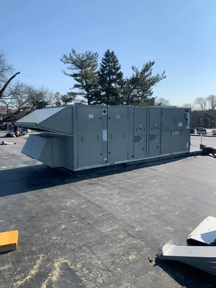 A large gray box is sitting on top of a roof.