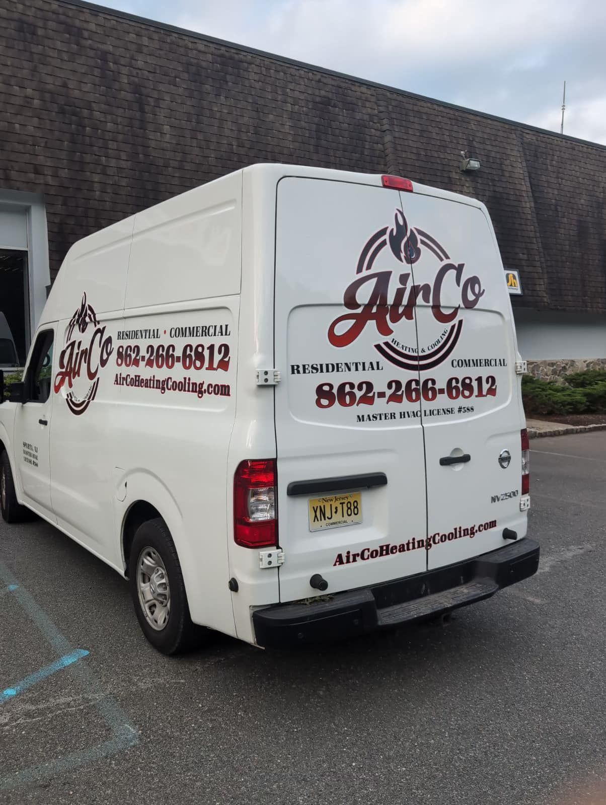 A white van is parked in front of a building.