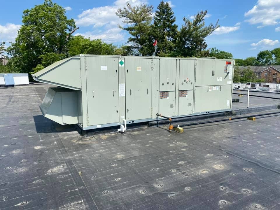 A large air conditioner is sitting on top of a roof.