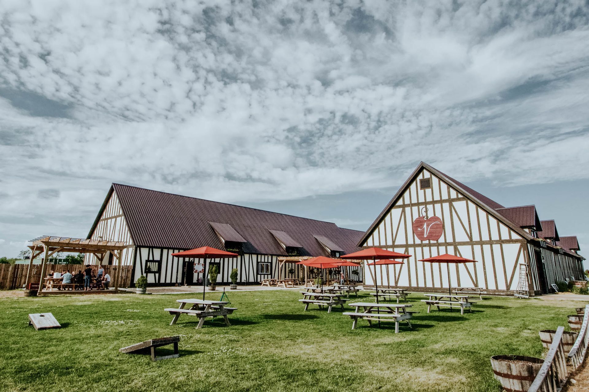 A large building with a lot of picnic tables and umbrellas in front of it.